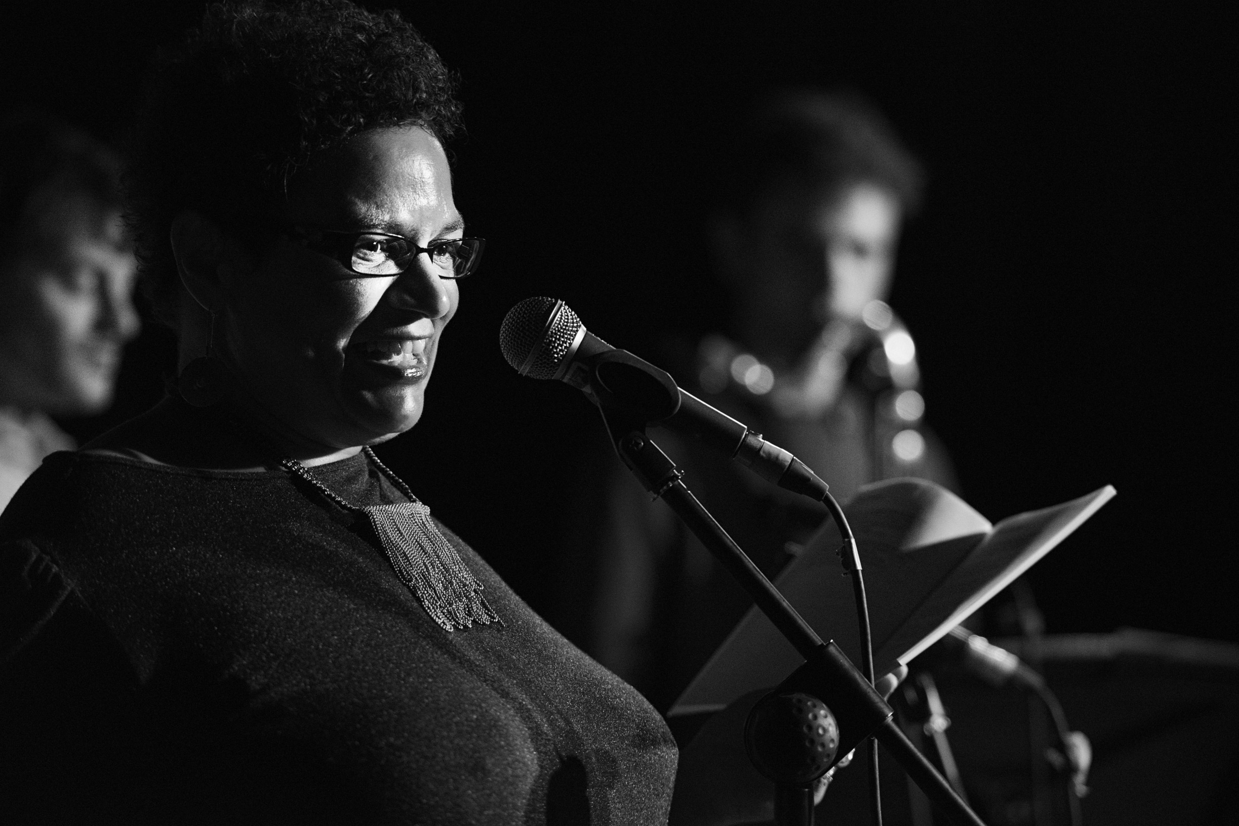 Jackie Kay performing with musicians in background
